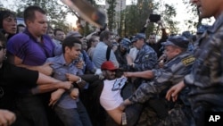 Police officers detain a protester in the opposition camp in Moscow