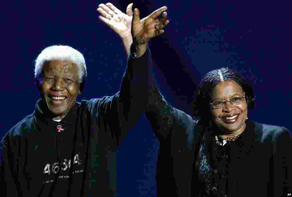 The former South African president, left, and his wife, Graca Machel, wave to the audience during a Live 8 concert in Johannesburg, South Africa, July 2, 2005. 